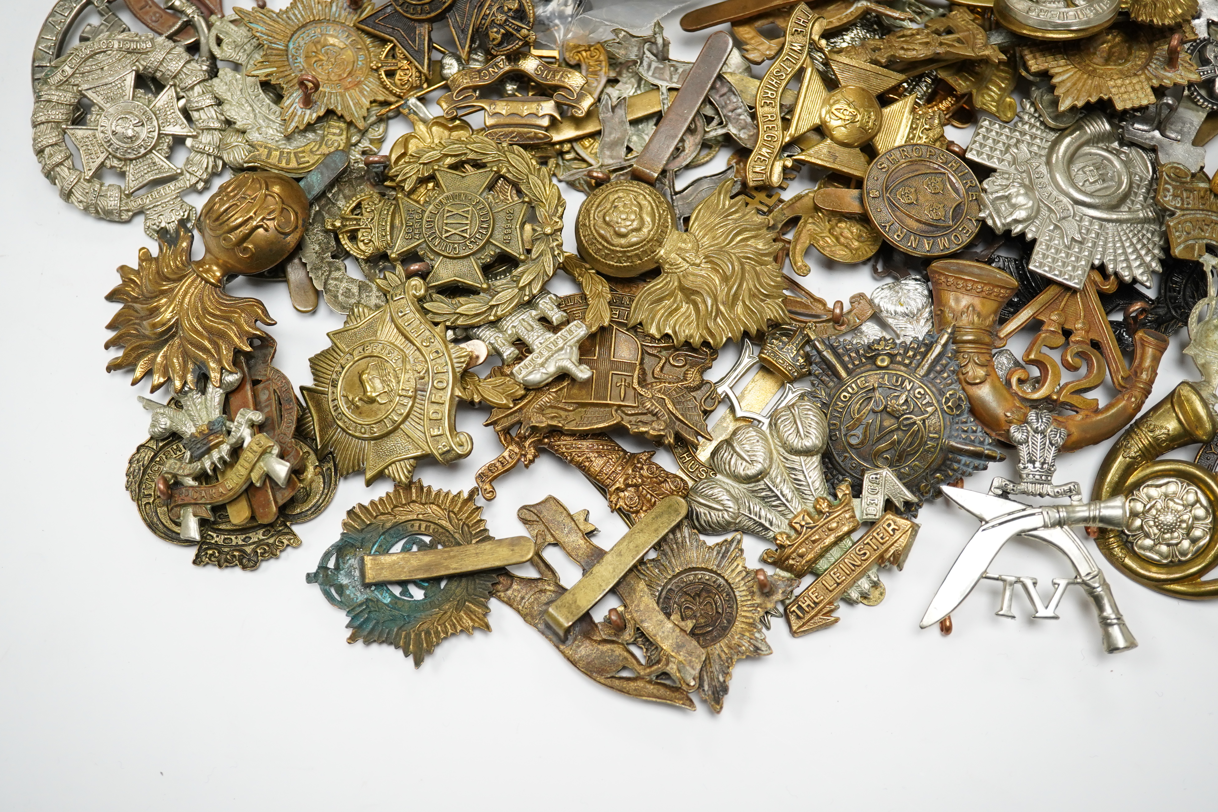 Seventy-eight military cap badges, including; the Royal Horse Artillery, the King’s Own, the Notts and Derby Regiment, the Royal Hussars, the Shropshire Yeomanry, the Herefordshire Regiment, the City of London Volunteer